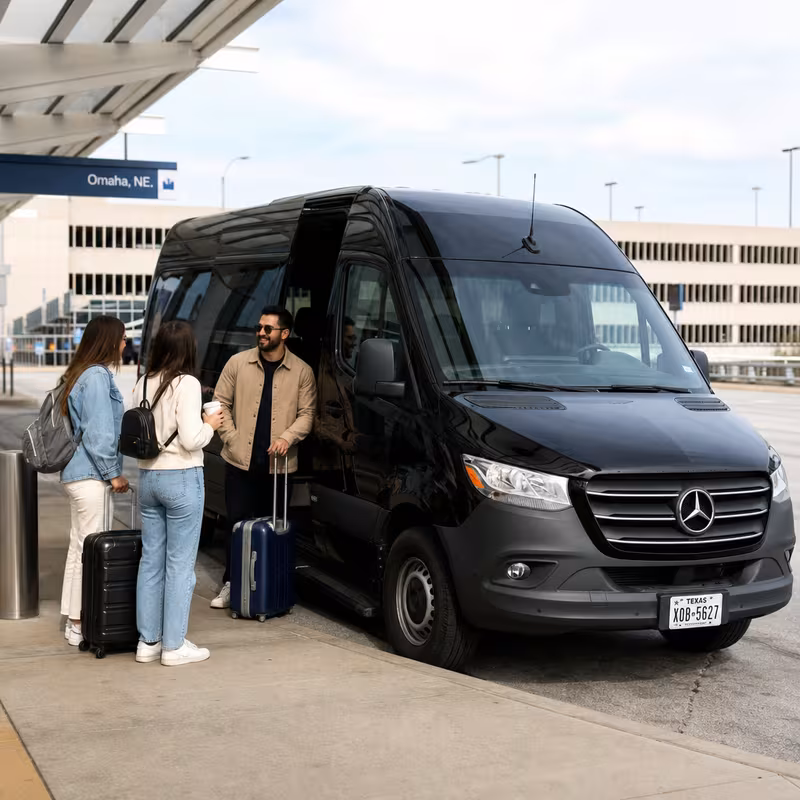 Group boarding a white charter bus for Airport Transportation transportation in Omaha