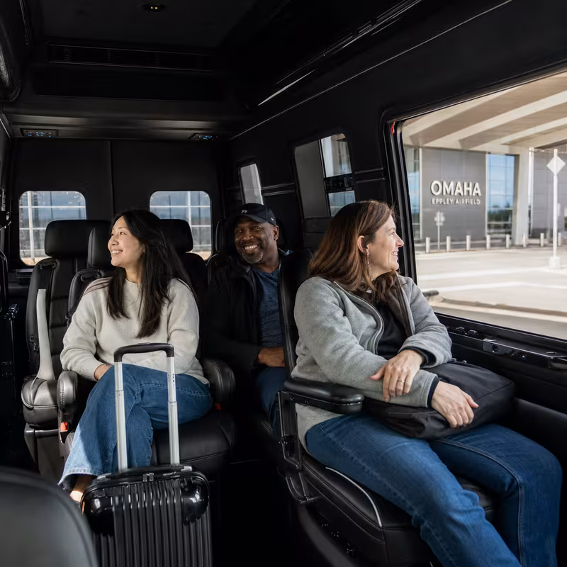 Passengers loading luggage while boarding an Omaha group shuttle