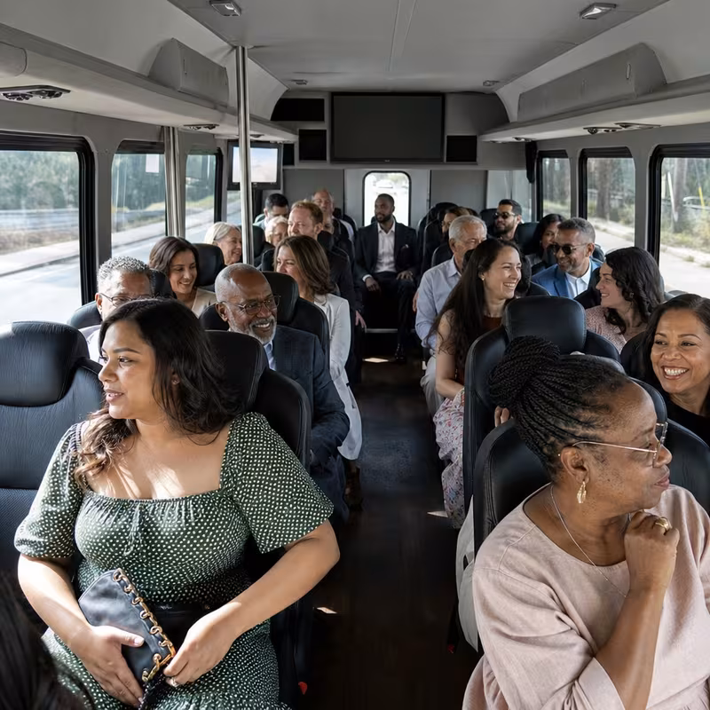Group boarding a white charter bus for Private Event Transportation transportation in Omaha