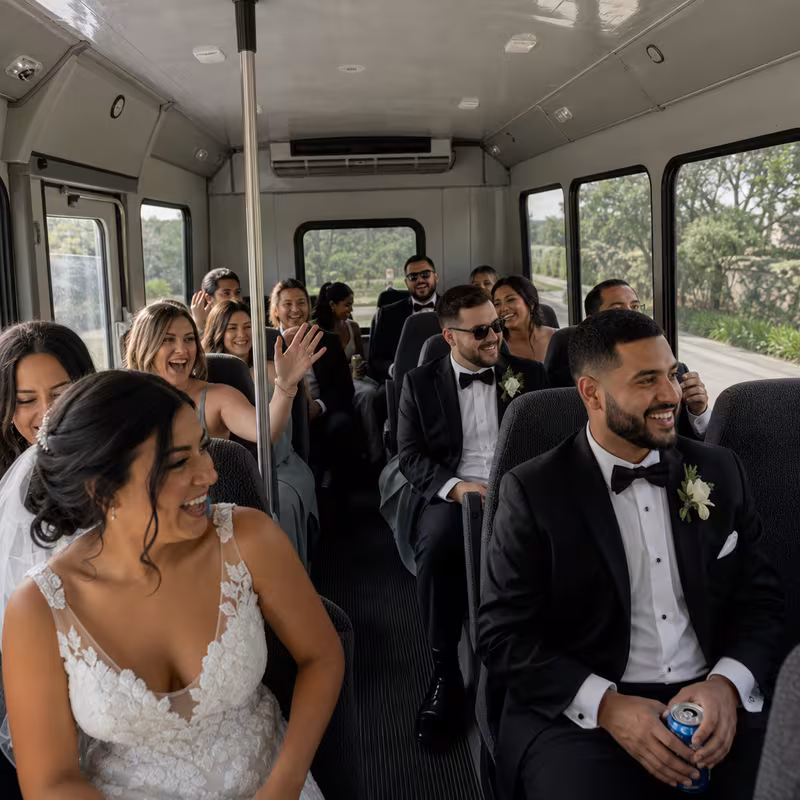 Group boarding a white charter bus for Wedding Transportation transportation in Omaha